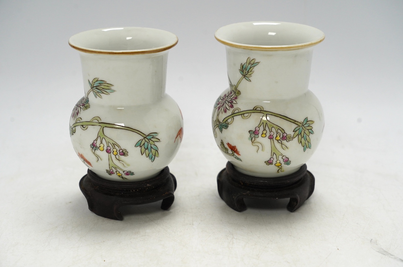 A pair of Chinese famille rose vases, mid 20th century, on wood stands, 10cm high. Condition - good